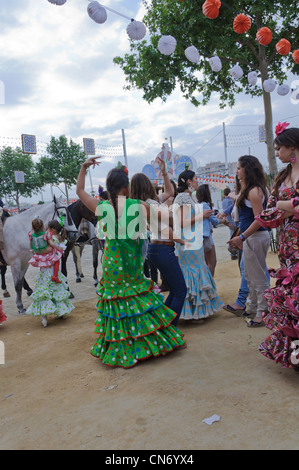 Le giovani ragazze vestite con il tradizionale costume di flamenco a Feria de Abril di Siviglia, Spagna. Foto Stock