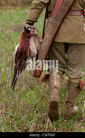 Un cacciatore porta shot fagiani e pernici Foto Stock