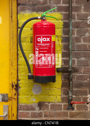 Estintore appeso nel luogo designato nella vecchia fabbrica in Groningen, Paesi Bassi Foto Stock