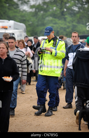 Un poliziotto a Stow-su-il-Wold fiera dei cavalli con palese sorveglianza video della folla Maggio 2009 REGNO UNITO Foto Stock