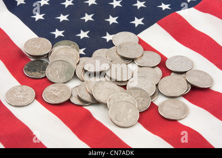 Pila di quarti sulla bandiera americana. Foto Stock