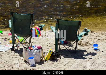 Due sedie campeggio su una spiaggia di sabbia, Arkansas River scorre attraverso il quartiere del centro storico della cittadina di salida, CO Foto Stock