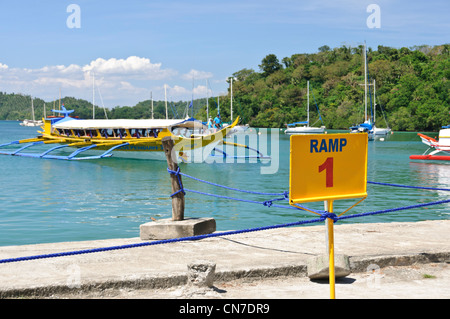 Banka banka passeggeri pendolari outrigger boat arrivando rampa 1 Muelle Pier Bay Puerto Galera Filippine Oriental Mindoro Asia Foto Stock