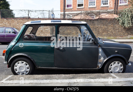 Vista laterale di una vecchia Mini Cooper parcheggiato sulla strada, London, England, Regno Unito Foto Stock