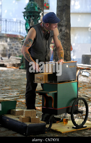 Francia, Parigi, Butte Montmartre, Valmy un musicista di strada con un organetto sulla Place Emile Goudeau Foto Stock