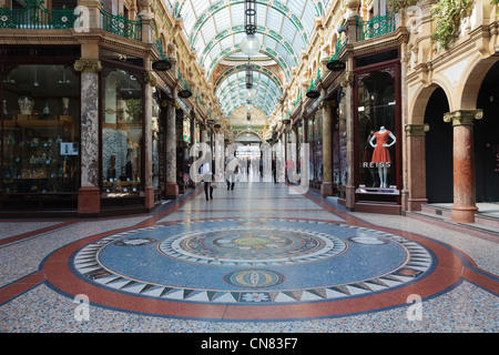 Pavimento a mosaico e la tradizionale sistemazione di negozi di designer nella contea di Arcade nel quartiere di Victoria shopping centre in Inghilterra Leeds REGNO UNITO Foto Stock