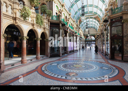 Pavimento a mosaico e la tradizionale sistemazione di negozi di designer nella contea di Arcade nel quartiere di Victoria shopping centre in Leeds Yorkshire England Regno Unito Gran Bretagna Foto Stock