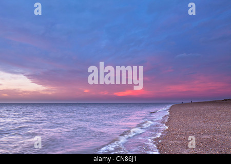 Impostazione inverno il sole illumina le nuvole nel cielo della sera oltre il lavaggio a Snettisham, Norfolk, Regno Unito. Foto Stock