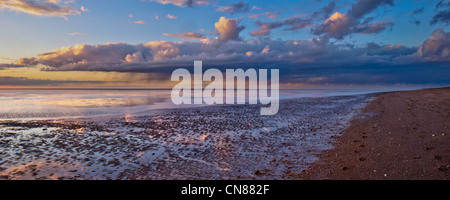 Panorama del tramonto di autunno e di docce sulla tranquilla spiaggia deserta a bassa marea a Snettisham, Norfolk, Regno Unito Foto Stock