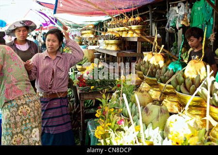 Una ragazza birmani in una bancarella di strada vende golden offerte al di fuori del Botataung Paya a Rangoon, Birmania Foto Stock