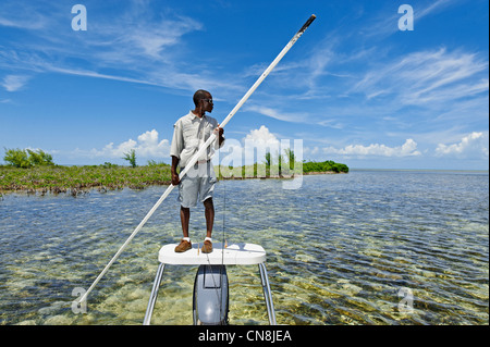 Bahamas, Grand Bahama Island, Città Sweeting, fly fisherman cercando una scuola di pesce Bonefish sui bassi fondi tra due Foto Stock