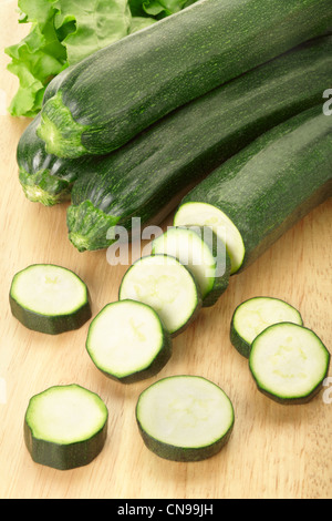 Zucchine o la zucchina tagliata a fette sul bordo di taglio Foto Stock