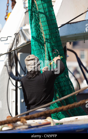 Deep sea filippino di lavoro dei pescatori, riparazione di reti da pesca nel porto di Peterhead.N.E.Scotland Regno Unito Foto Stock