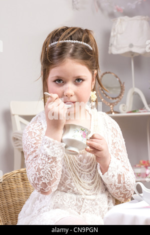 Una bellissima bambina avente un tea party Foto Stock