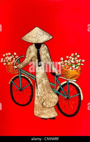 Pittura colorata di una donna vietnamita in piedi accanto a una bicicletta, Vietnam Foto Stock