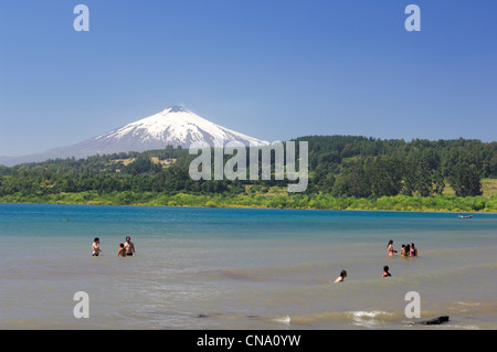 Il Cile, Los Lagos regione, provincia Araucania, Villarica, bagnanti nel Lago Villarrica con il Vulcano Villarrica in background Foto Stock