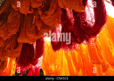Appena tinta rosso e arancione matasse di lana appendere essiccazione al sole presso la lana Dyers souk della medina, Marrakech, Marocco Foto Stock