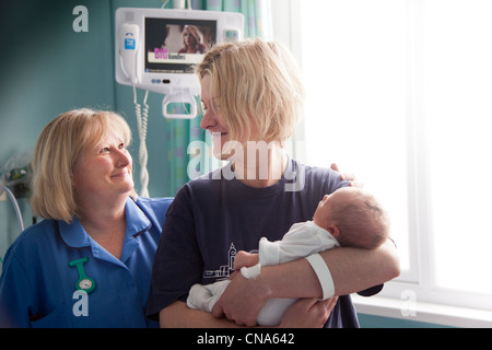 Senior del personale ospedaliero parla di una mamma dopo il parto REGNO UNITO Foto Stock