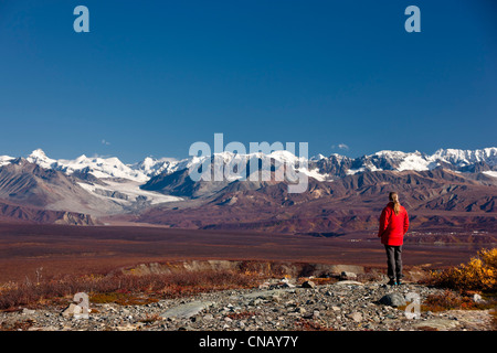 La donna si gode della vista del Vertice Lago e l'Alaska Range dal Denali autostrada vicino Paxson, Interior Alaska, Autunno Foto Stock