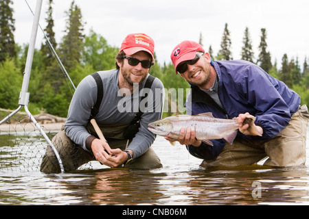 Due pescatori a mosca in attesa del loro pescato Il Salmone Sockeye, Koktuli fiume in Bristol Bay Area, Southwest Alaska, estate Foto Stock