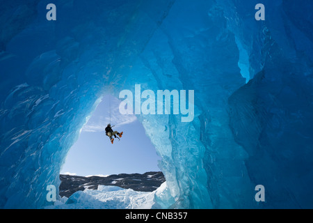 Composito: vista dall'interno di una caverna di ghiaccio di un iceberg come un alpinista rappels giù, Mendenhall Glacier, Alaska Foto Stock