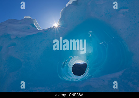 Piccolo tunnel erosi in un iceberg congelati in Mendenhall Lago, Juneau, a sud-est di Alaska, inverno Foto Stock