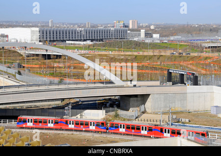 Docklands Light Railway treno in partenza nuova stazione internazionale di Stratford con il Westfield access bridge & Sito olimpico al di là Foto Stock