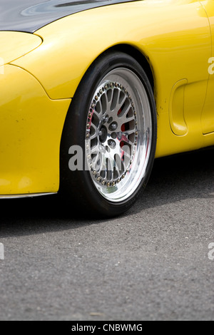 Un primo piano dei cerchioni personalizzati sulle moderne auto sportive con abbondanza di copyspace. Foto Stock