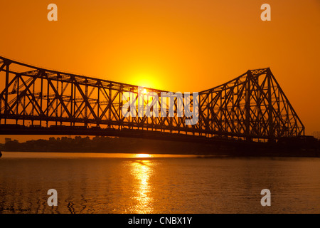 India Bengala Occidentale, Kolkata (Calcutta), tramonto dietro quella di Howrah ponte di sospensione Foto Stock