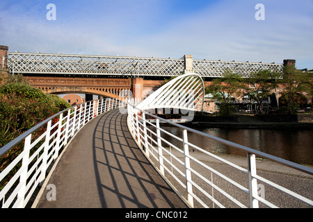 Inghilterra, Manchester, Castlefield, Bridgewater Canal, Vittoriano ponte ferroviario e il moderno ponte di sospensione Foto Stock