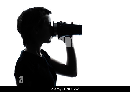 Un caucasian adolescente di bere a thermos travel mug silhouette ragazzo o ragazza ritratto in studio di ritagliare isolati su sfondo bianco Foto Stock