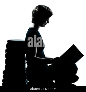 Un caucasian adolescente silhouette ragazzo o ragazza la lettura a lunghezza piena in studio di ritagliare isolati su sfondo bianco Foto Stock