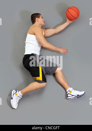 Muscolare di giocatore di basket cattura la sfera, panoramica Foto Stock