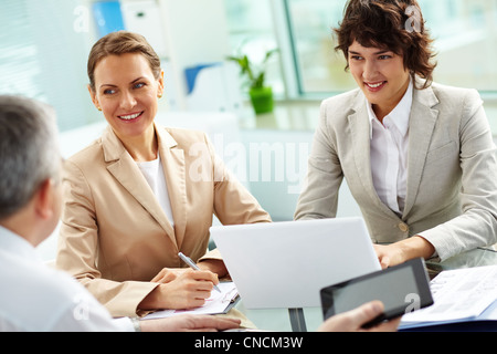 Le donne d'affari in ascolto attento al loro vecchio collega esperto Foto Stock