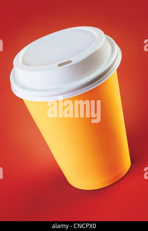 Tazza di caffè fuori su uno sfondo rosso Foto Stock
