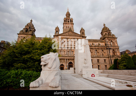 Lion statua presso il Cenotafio Memoriale di guerra a George Square, City Chambers dietro, a Glasgow in Scozia. Foto Stock