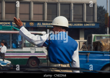 La vita di strada dominata dal risciò e automobili. Qui un poliziotto in piedi al centro di una strada Foto Stock