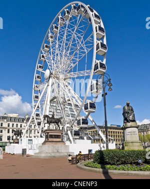 La ruota di Glasgow in George Square Glasgow Scozia presentato da grandi attrazioni della città con la statua di James Watt a destra. Foto Stock