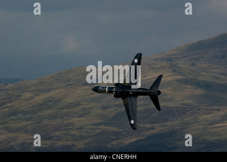 Un RAF 19 Sqn BAe Hawk T1un getto veloce trainer tira attraverso un passo di montagna in un coltello bordo oltre il Parco Nazionale di Snowdonia Foto Stock