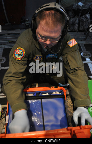 Master Sgt. Michael Hensala, di Cheyenne, Wyo., assegnato come tecnico medico con il 187° Squadron di evacuazione Aeromedica, cerca forniture mediche durante un volo di addestramento a bordo di un aereo da carico C-130, 13 aprile 2012. L'unità è specializzata nella fornitura di servizi di ambulanza aerea a bordo di aerei da carico dell'aeronautica, trasportando i malati e i feriti dalle zone di combattimento a luoghi più sicuri. Foto Stock