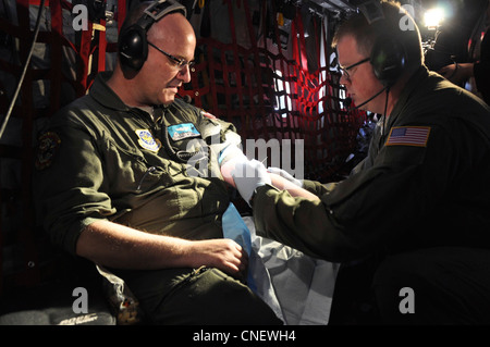 Master Sgt. Michael Hensala, di Cheyenne, Wyo., si prepara a iniziare un IV per scopi di formazione, su staff Sgt. Cliff Knesel, di Gillette, Wyo., durante un volo di addestramento, su un aereo da carico C-130, 13 aprile 2012. Entrambi sono assegnati come tecnici medici con il 187° Squadrone di evacuazione Aeromedica. Il 187 è specializzato nella fornitura di servizi di ambulanza aerea a bordo di aerei da carico dell'aeronautica, trasportando i malati e feriti dalle zone di combattimento a luoghi più sicuri. Foto Stock