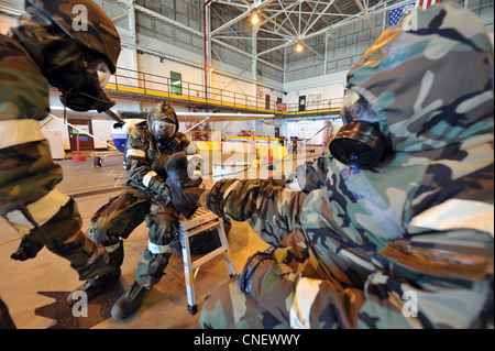 I membri della 140a ala si aiutano a rimuovere i loro copriabiti protettivi chimici durante l'elaborazione attraverso l'area di controllo della contaminazione durante un esercizio di preparazione operativa presso la Buckley Air Force base, Colon., 13 aprile 2012. Il CCA è un'area designata per rimuovere indumenti protettivi chimici contaminati attraverso un processo che consente di evitare che le sostanze contaminanti causino danni agli elementi durante la rimozione degli elementi protettivi. I membri della guardia stanno partecipando all'esercizio per prepararsi alle implementazioni del mondo reale e all'imminente ispezione di preparazione operativa a maggio. Foto Stock