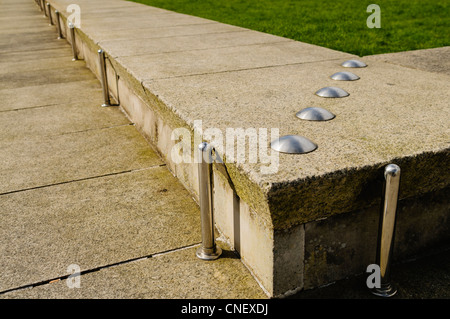 Anti-skateboard a dispositivi installati su un basso muro di pietra Foto Stock