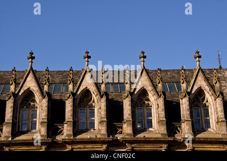 Sun riflette le ombre tra le righe di Scottish ottocento stile gotico finestre ad arco su un vecchio edificio elencato a Dundee, Regno Unito Foto Stock