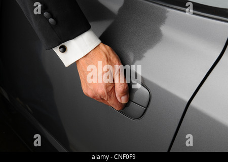 Una mano d'uomo sulla porta auto sullo sfondo di una femmina di silhouette  in lo specchio del retrovisore Foto stock - Alamy