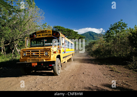 Nicaragua Isla Ometepe sul Lago di Nicaragua bus di pollo in movimento su strada di ghiaia con vulcano madera in background isola di Ometepe Foto Stock