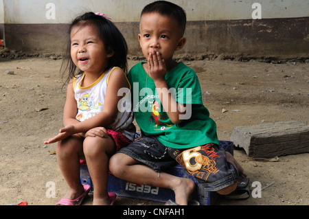 Lao giovane ragazzo e ragazza seduta divieto Ou village Laos Foto Stock