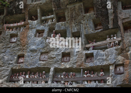 Indonesia Sulawesi, Tana Toraja area, Suaya village, re della pietra memorial tombe con legno tau tau effigi dei morti. Foto Stock