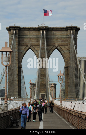 Ritratto, verso Manhattan, bandiera americana, cavi di sospensione tower, uomo orientali, Ponte di Brooklyn Pedonale, New York Foto Stock