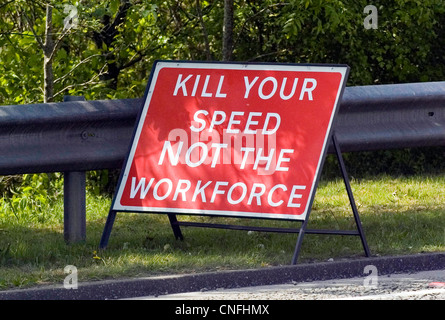 "Uccidere la tua velocità non la forza lavoro " segno sulla strada principale fuori Llanelli in Galles del Sud, precedendo di lavori stradali. Foto Stock